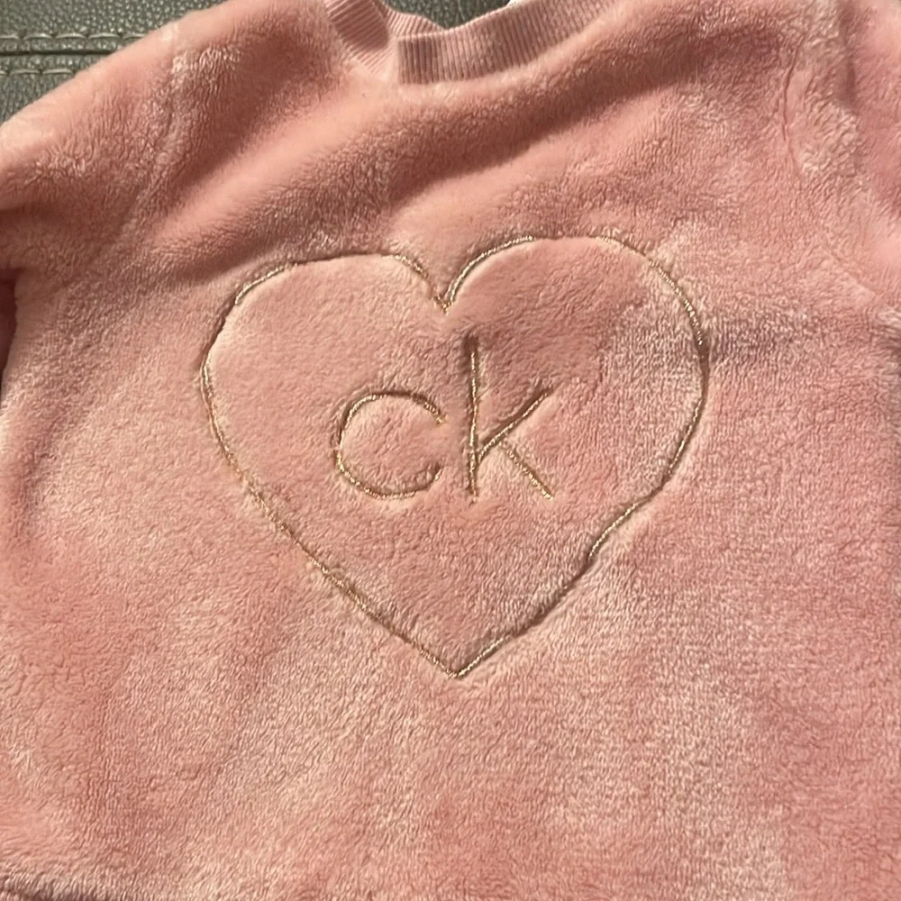 Calvin Klein size 12 months. Soft pink‎ two snap buttons behind neck. GUC.